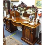 A Victorian mahogany mirror-back pedestal serpentine Sideboard, of large size with carved