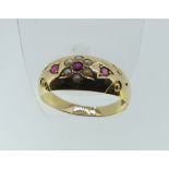 A 15ct yellow gold Ring, the front set with rubies and seed pearls forming a flowerhead, Size P,