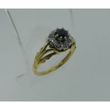 A small 18ct gold sapphire and diamond Ring, the central circular facetted sapphire surrounded by
