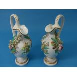 A pair of 19thC German Jugs, with an intricate painted raised floral and foliate pattern to the