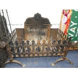 An antique cast iron Fire Grate, the Fire-Back panel with scrolled edge, above an open Fire Basket