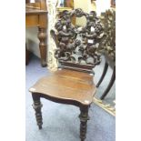 A Victorian mahogany carved Hall Chair, with foliate and cherub carved design, upon turned legs,