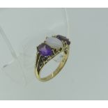 An opal and amethyst three stone Ring, the central oval opal with a facetted oval amethyst on either