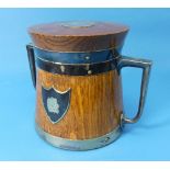 An Arts & Crafts silver plate mounted oak Biscuit Barrel, with hinged lid and ceramic liner, the