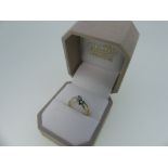 A small 14kt yellow gold Ring, set on the cross with two flowerheads, one of five emeralds with