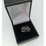 A diamond set crossover Ring, formed of two flowerheads, each with nine small diamonds, mounted on
