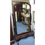 A Victorian mahogany Cheval Mirror, the arched rectangular plate with a moulded frame on scroll