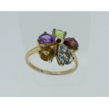 A pretty 9ct gold Dress Ring, the front formed of a flowerhead with harlequin set stones, Size L½.