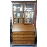 A Georgian oak Bureau with associated Bookcase top, with dentil cornice and astragal glazing,