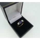 A three stone sapphire and diamond Ring, the oval facetted (synthetic) sapphire, with an old cut