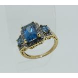 A graduated three stone Topaz Dress Ring, of stepped form, each stone with small diamond point
