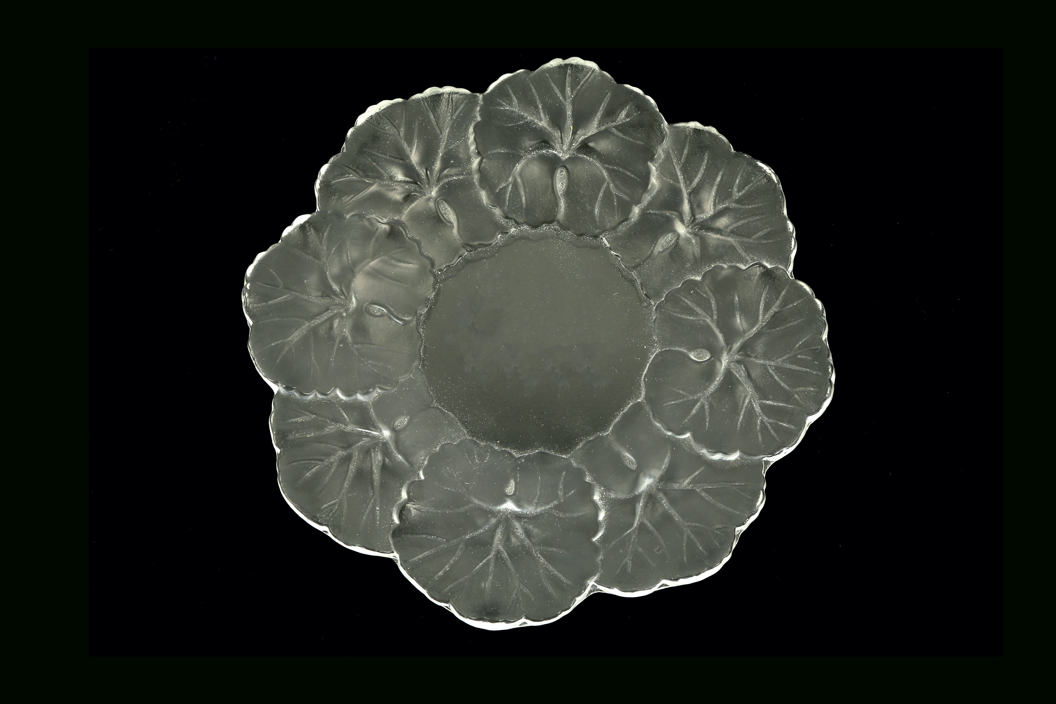 A 20th century Lalique France 'Honfleur' glass plate, of small circular form with a leaf pattern
