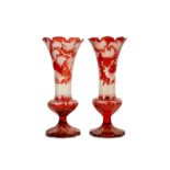 A PAIR OF 19TH CENTURY BOHEMIAN RUBY GLASS VASES of trumpet form, with scallop edge rims, the bodies