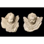 A PAIR OF VENETIAN MARMORINO PLASTER HEADS OF PUTTI, PROBABLY 18TH CENTURY the winged putti with