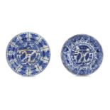 *A NEAR PAIR OF CHINESE-INSPIRED BLUE AND WHITE POTTERY DISHES