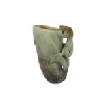 A Chinese pale celadon jade archaistic dragon rhyton.