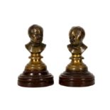 A pair of late 19th/early 20th century French patinated bronze miniature busts of infants