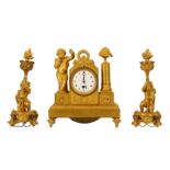 An early 19th century French Empire period small gilt bronze mantel clock garniture depicting Cupid