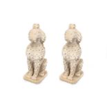 A pair of weathered reconstituted stone garden figures of poodles