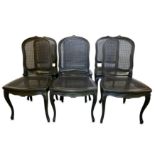 A set of six blackened oak and caned French Louis XV style dining chairs