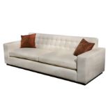 A large contemporary fabric upholstered sofa in cream,