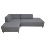 A contemporary corner sofa upholstered in grey fabric