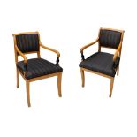 A pair of Biedermeier satin birch and ebonised open armchairs