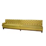 A contemporary button back banquette upholstered in yellow leather