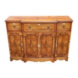 A George III style yew wood breakfront sideboard