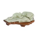 A Chinese pale celadon jade group modelled as a recumbant cat with kitten,