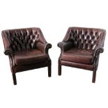 A pair of contemporary brown leather club chairs from The Goring Hotel, London