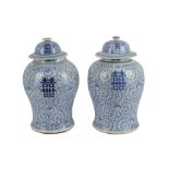 A near pair of Chinese blue and white porcelain jars and covers