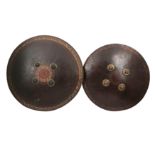 TWO INDIAN POLYCHROME-PAINTED AND LACQUERED LEATHER SHIELDS (DHAL)