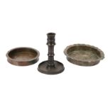 TWO COPPER ALLOY ENGRAVED DISHES AND A CANDLESTICK