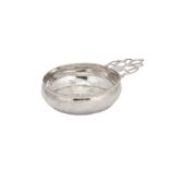 A Queen Anne unmarked silver single handle porringer, probably London circa 1710