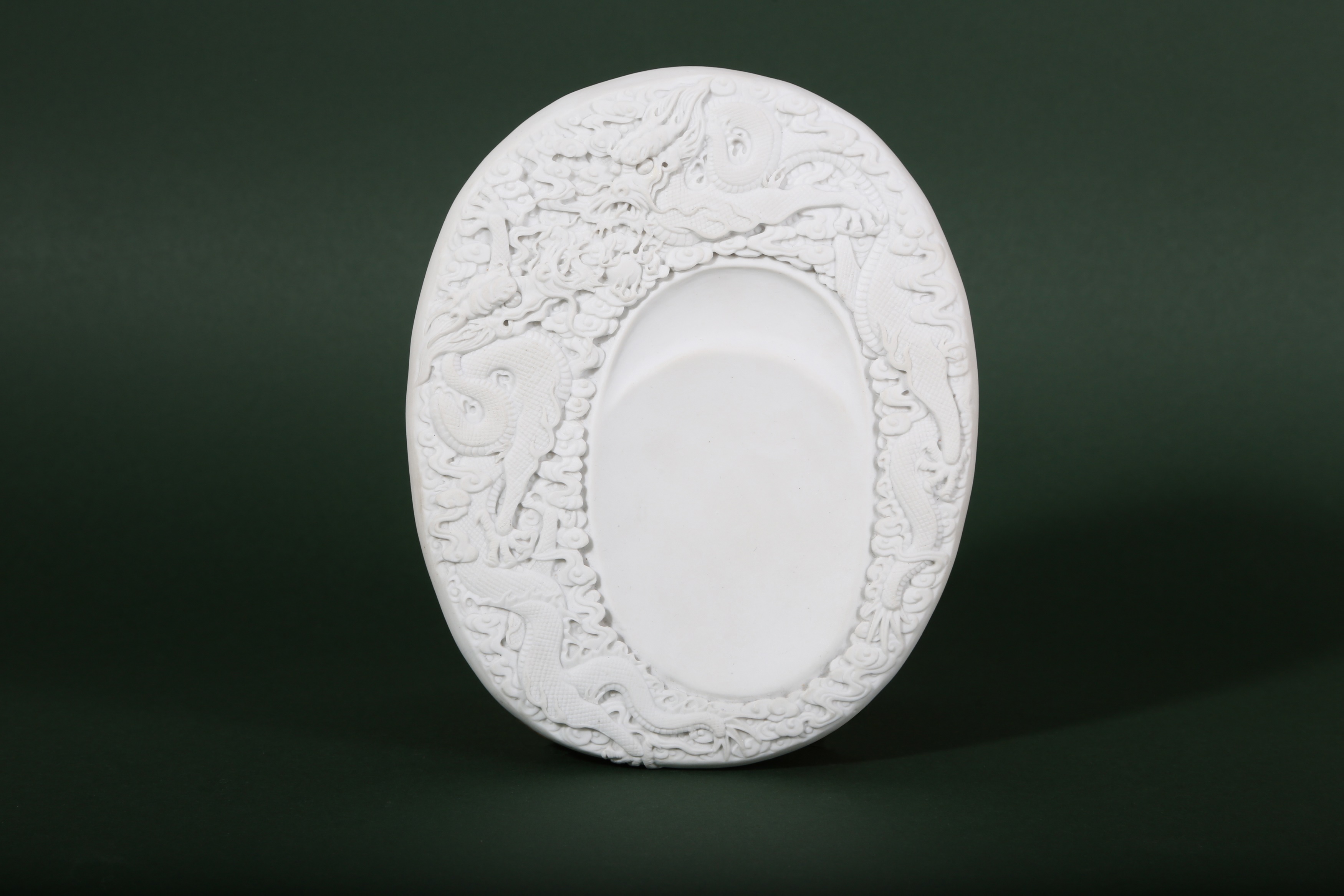 A CHINESE WHITE BISCUIT 'DRAGON' INKSTONE.