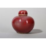 A SMALL CHINESE COPPER RED-GLAZED JAR AND COVER.
