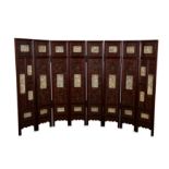 λ A CHINESE EIGHT PANEL IVORY-INSET LACQUER SCREEN.