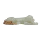 A CHINESE PALE CELADON JADE CARVING OF A DOG.