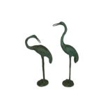 A pair of green patinated bronze garden sculptures of cranes,