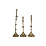 A Near Pair of Brass Candlesticks and an Individual Tall Candlestick