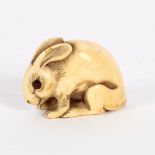 A Japanese ivory netsuke, 18th/19th Century, in the form of a crouching hare,