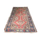 A Mazlaghan rug, West Persia, circa 1880, the madder field with three serrated medallions,