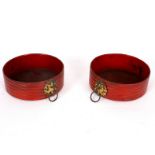 A pair of Regency red japanned reeded papier-mâché coasters, with brass lion mask handles, 13.