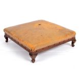 A beechwood footstool, with a square leather upholstered seat, on short cabriole legs, 48.