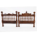 An Iberian carved walnut bedhead and footboard, 19th Century, boldly carved and turned, 97cm wide,