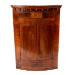 A William IV mahogany bow-fronted hanging corner cupboard, circa 1835,