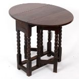 An oak oval two-flap gate leg table, on bobbin turned legs and square stretchers, 59.