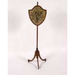 A satinwood pole screen, the shield-shaped needlework banner on a tripod base,
