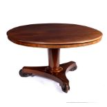 An early Victorian circular table on a tapered column and flat tripod base with scroll feet,